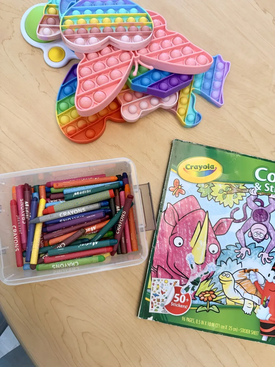 Pop-it fidget toys, a box of crayons and a coloring book